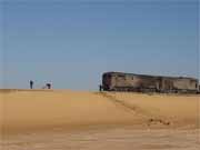 Train is trying to go through desert. Employers are cleaning track from sand. Sahara desert. Egypt.