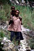 Villager from Dani tribe carrying small child. Indonesia.