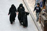 Women at traditional black clothes at street at old quarter of Sana capitol. Yemen.